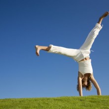 Young woman doing cartwheel on grass