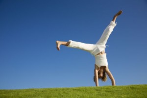 Young woman doing cartwheel on grass